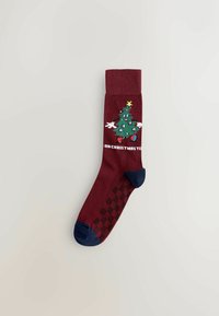 Mørkerød sok med et grønt juleskabsdesign, blå tåaccent og teksten "ÅH JULETRÆ," samt et struktureret grebmønster på sålen.