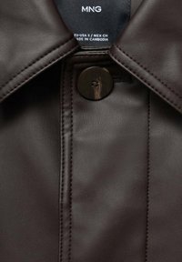 Braune Kunstlederjacke mit kragenförmigem Ausschnitt, Knopfverschluss und sichtbaren Nähdetails, mit einer glatten Textur.