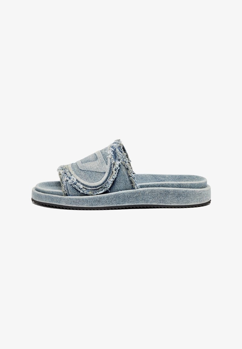 Denim slide sandals with frayed edges, a prominent logo on the strap, and a cushioned sole, featuring a light blue color and textured design.
