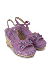 Paarse suede wedge sandalen met enkelbandjes, versierd met kristalachtige accenten, en een geweven jute platform voor extra hoogte.
