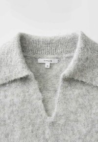 Pull en maille gris clair avec col replié et encolure en V profonde, avec une étiquette de la marque Opus et une étiquette de taille 36 à l'intérieur du col.