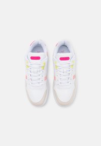 White sneakers with pink and yellow accents, featuring a smooth leather exterior, round toe, and traditional lace-up design.