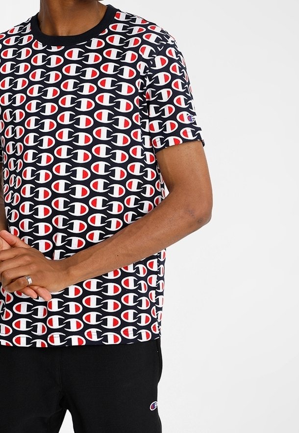 T-shirt nera a maniche corte con un motivo a logo ripetuto in rosso, bianco e nero. Realizzato in tessuto liscio con scollatura rotonda.