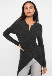 Cardigã de mangas longas em cinza escuro, feito de um tecido suave, com fecho de botão, apresentando uma bainha assimétrica e detalhes franzidos na parte da frente.