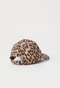 Caps cu imprimeu de leopard în nuanțe de bej și negru, din material textil, cu vizieră curbă, curea ajustabilă în spate, accente din metal.