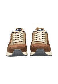 Braune Wildleder- und Ledersneaker mit beigen Akzenten, cremefarbenen Schnürsenkeln, Gummisohlen und einem blauen Etikett an der Zunge. Strukturiertes Fersendetail.