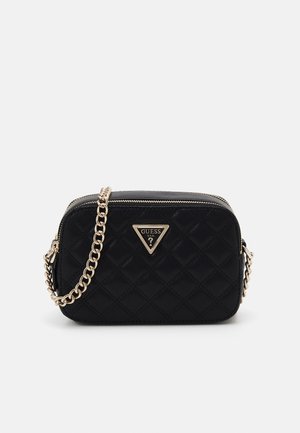 Sac à main capitonné noir avec une chaîne en or, présentant une plaque logo triangulaire à l'avant. Le matériau est lisse avec une finition brillante.