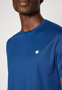 Blauwe korte mouwen t-shirt van gestructureerde stof. Heeft een ronde hals en een klein wit logo op de borst.