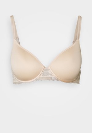 Beige padded bra with smooth cups, adjustable straps, and lace detailing at the band. Provides a seamless look and support.