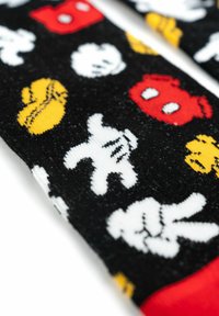 Calzini neri con colorati motivi di mani da cartone animate bianche, rosse e gialle, palline da baseball e altri motivi giocosi. Morbido tessuto lavorato a maglia.