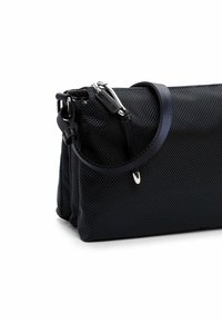 Borsa in tessuto nero testurizzato con chiusura a zip, tracolla regolabile e dettagli in metallo argentato. Design compatto con una forma strutturata.