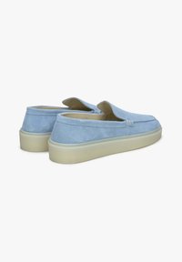 Jasnoniebieskie zamszowe buty wsuwane o niskim profilu, zaokrąglonym nosku i beżowej gumowej podeszwie. Posiadają minimalne szwy i boczne otwory.