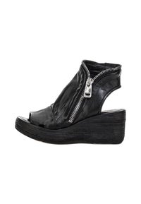 Czarne skórzane sandały na koturnie z odkrytymi palcami, asymetrycznym wzornictwem, bocznym zamkiem błyskawicznym oraz teksturowaną drewnianą podeszwą dla dodatkowego kontrastu.