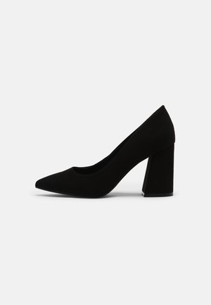 Black suede high heel pump with a pointed toe and a wide block heel, featuring a smooth texture and a minimalist design.