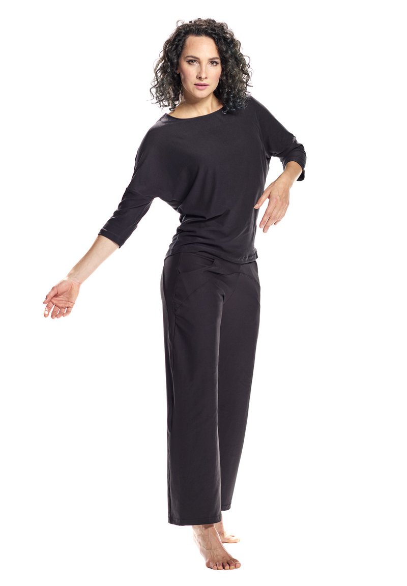 Black relaxed-fit top with wide neckline and three-quarter sleeves, paired with matching loose-fit trousers, both made from soft fabric.