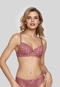 Lace bra in dusty rose color with scalloped edges, zigzag pattern, and a central bow detail. Paired with matching lace panties.