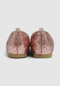 Różowe złote płaskie buty z cekinami, z miękką górną częścią z materiału, okrągłym noskiem i prostą elastyczną opaską z tyłu dla łatwego zakupu.