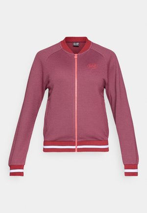 Giacca a zip bordeaux con polsini e orlo a costine, caratterizzata da righe bianche e rosse. Logo visibile sulla parte sinistra del petto. Texture liscia.