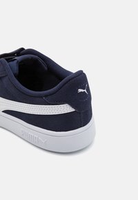 Baskette Puma bleu marine avec bande blanche et logo sur le talon, semelle blanche, vue de l'arrière côté droit sur fond uni.
