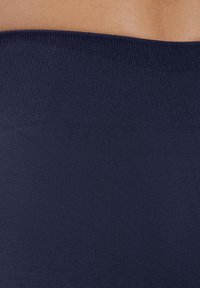Marineblauwe ribstof met een gladde textuur, voorzien van een brede tailleband die plat en comfortabel tegen de huid aanligt.