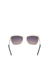 Occhiali da sole oro e neri con un design geometrico. Le lenti sono sfumate da scure a chiare. Montatura in metallo leggera con naselli trasparenti.