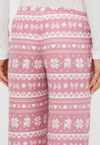 Rozā rakstainas bikses ar baltām lentītēm, sirsniņām un briežu ilustrācijām. Izgatavotas no mīksta auduma ar ērtu elastīgu vidukļa jostu.