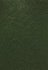 Dunkelgrüne gestrickte Stofftextur mit sichtbarem Strickmuster und leichten Variationen in der Fadendicke.