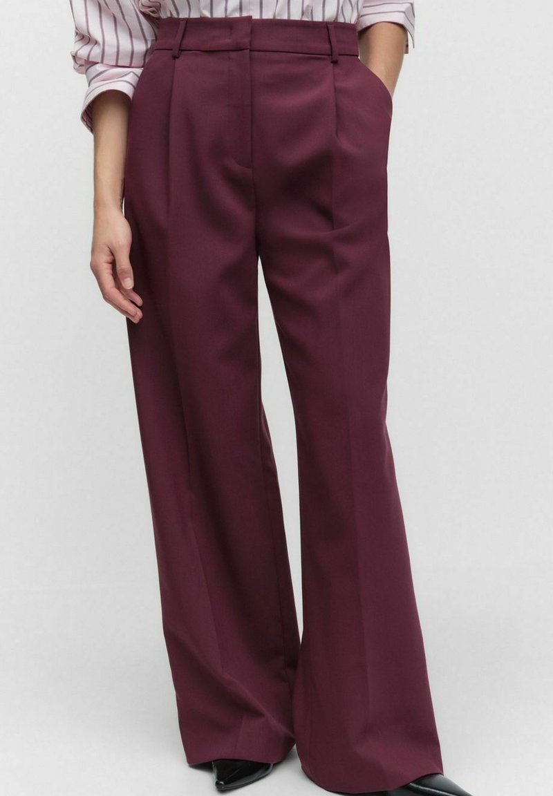 Wide-leg trousers in a deep burgundy color, made from a smooth fabric. Features belt loops and subtle front pleats.