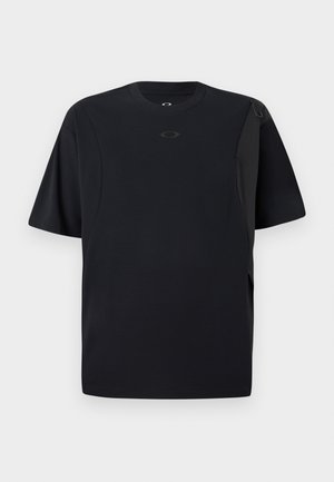 Črna kratkosleeve majica iz gladkega materiala, z asimetričnim dizajnom in majhnim logotipom na prsih.