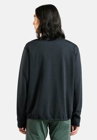 Dunkelgrauer Langarm-Sweatshirt mit strukturiertem Material, Rundhalsausschnitt, Tropfensaum und gerippten Bündchen, kombiniert mit grünen Hosen.