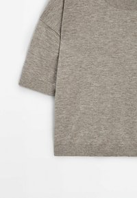 Vaaleanharmaa neulepaita, jossa on pyöreä kaula-aukko, lyhyet hihat ja ribbaus helmassa. Pehmeä texture ja yksinkertainen, tasainen kuvio.