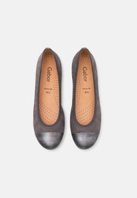 Pelēko zamšādas baleta apavus ar metāla galiem, perforētu zoli un zīmola marķējumu iekšpusē, ar vienkāršu, apaļu dizainu.