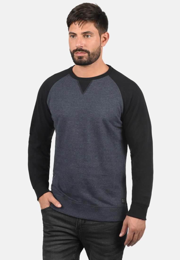 Felpa blu scuro con maniche raglan nere, dotata di scollatura a girocollo, texture morbida e una piccola etichetta del marchio in basso.