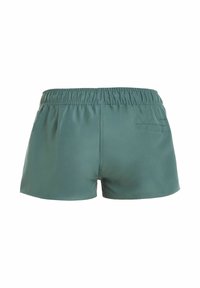 Groene short met elastische tailleband en een achterzak aan de rechterkant, gezien van achteren op een witte achtergrond.