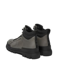 Augsti pelēki sporta apavi ar spīdīgu ādas virsmu un melnu gumijas zoli. Aprīkoti ar polsterētu apkakli un G-Star logotipa detaļu papēdī.