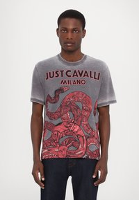 Grijze t-shirt met korte mouwen, met rode serpentine graphics en de tekst "JUST CAVALLI MILANO". Zachte, gladde textuur met een ontspannen pasvorm.