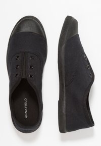 Canvas slip-on skor i mörk marin med en svart gummisul och tånobb. Har fem öglor och en strukturerad sula för grepp.