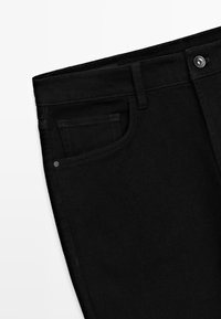 Zwarte denim jeans met een klassiek ontwerp, vijf-pocketstijl en een ritssluiting met een metalen knoopsluiting. Glad textuur en een nauwsluitende pasvorm.