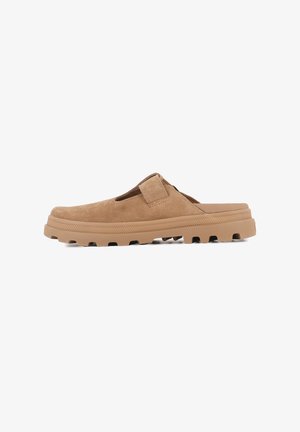 Chaussure slip-on en daim marron avec un upper texturé, une sangle à boucle et une épaisse semelle en caoutchouc avec un motif de crampons.