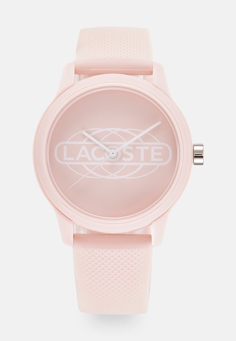 Montre bracelet Lacoste rose avec un bracelet en silicone texturé et un cadran minimaliste présentant le logo Lacoste ainsi que des aiguilles blanches pour les heures, les minutes et les secondes.