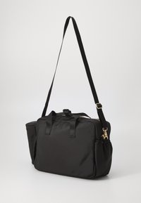 Sac en tissu noir de forme rectangulaire, avec deux poignées, une longue sangle réglable et une poche latérale. Fermeture éclair et accents de quincaillerie en ton doré.