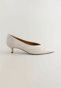 Bílé lakované lodičky s špičatou špičkou, elegantním designem a malým, štíhlým podpatkem. Hladký povrch a minimalistický styl.