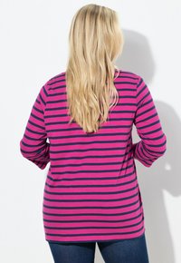 Maglietta a maniche lunghe con righe orizzontali rosa e blu navy, dal taglio rilassato e orlo arrotondato, realizzata in un tessuto morbido ed elastico.