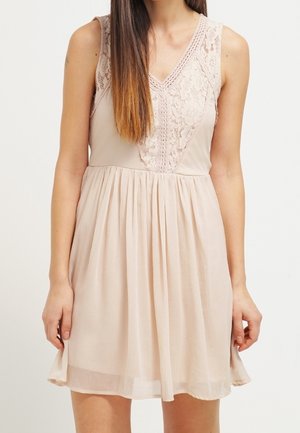 Vestido sin mangas de un suave tono rosa pálido, con un cuerpo de encaje, escote en V y falda fruncida. Textura lisa con pliegues sutiles y una forma fluida.