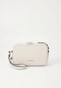 Textured white leather crossbody bag with a zip closure, adjustable strap, and minimalistic logo detail in silver. Rectangular shape.