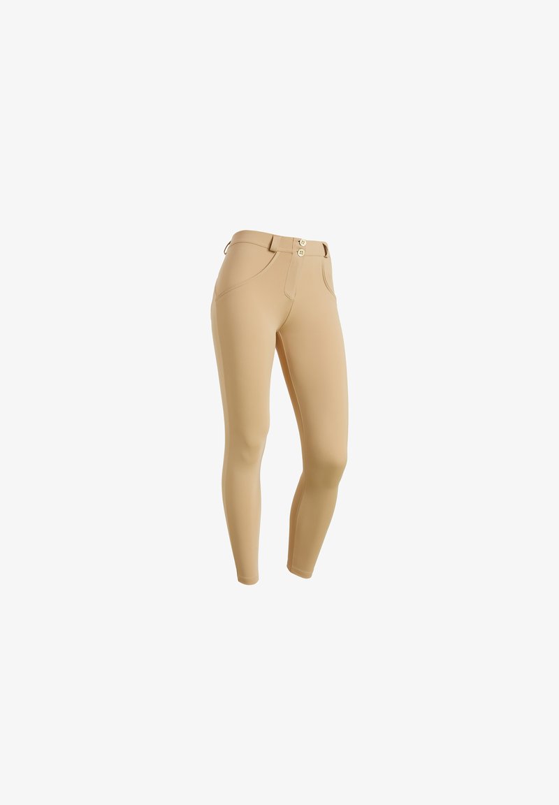 Leggings beige con un material suave y elástico. Presentan una cinturilla con dos botones y bolsillos frontales. Diseño ajustado con una silueta elegante.