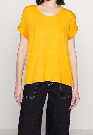 Yellow short-sleeve t-shirt with a round neckline and rolled cuffs, made from a lightweight fabric. Paired with black wide-leg pants featuring white stitching.