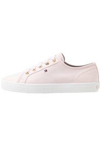 Světlé růžové plátěné tenisky se zlatými očky, bíla gumová podrážka a diskrétní branding poblíž paty. Zaoblená špička a šněrovací design.