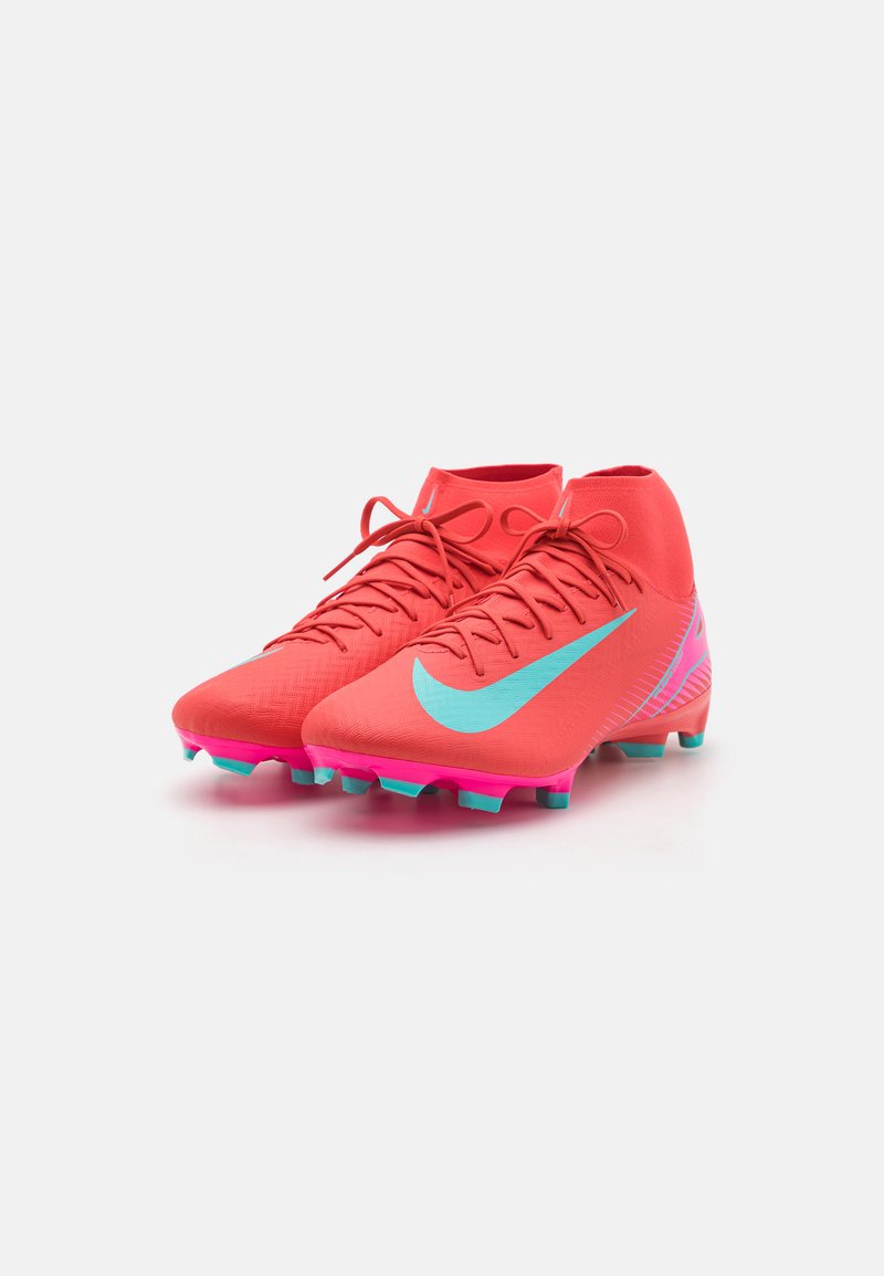 Scarpe da calcio rosse con design alto, caratterizzate da un logo Nike di colore azzurro chiaro, una parte superiore testurizzata e dettagli rosa sulla suola e i tacchetti.