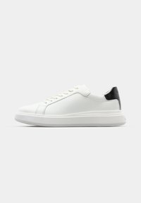 White leather sneaker with a smooth finish, round toe, and stitched details, featuring a black leather heel accent and white rubber sole.